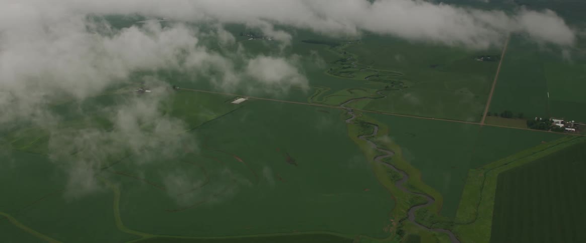 Aerial view of a grassland with clouds floating