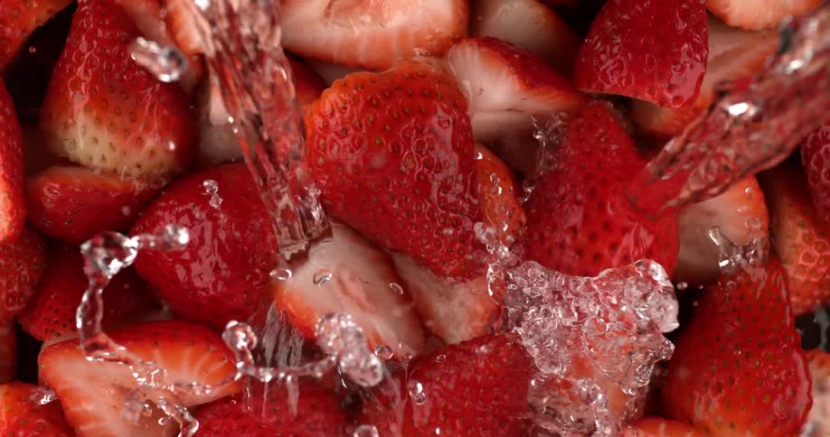 Water being poured on fresh cut strawberries