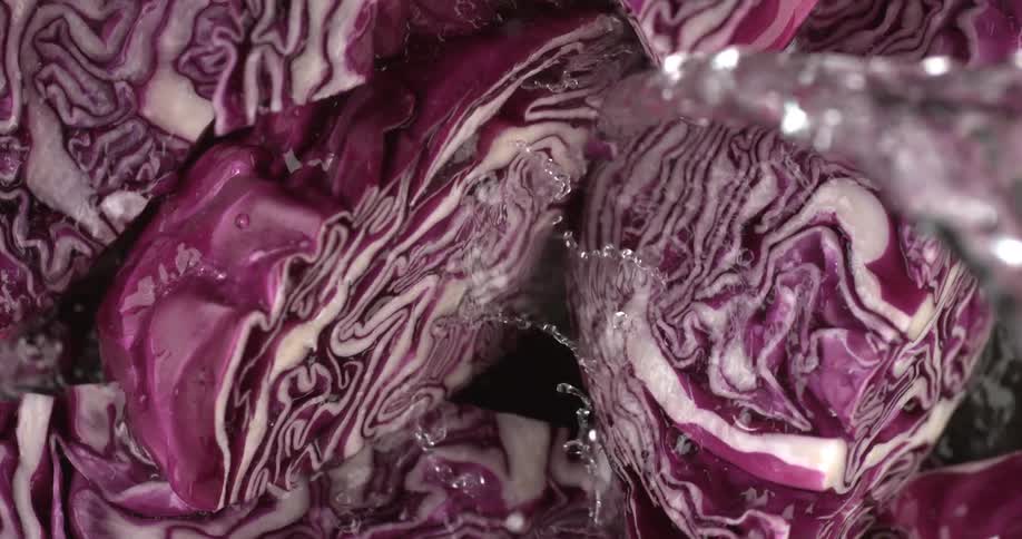 Clear water is splashed over a bunch of chopped red cabbage