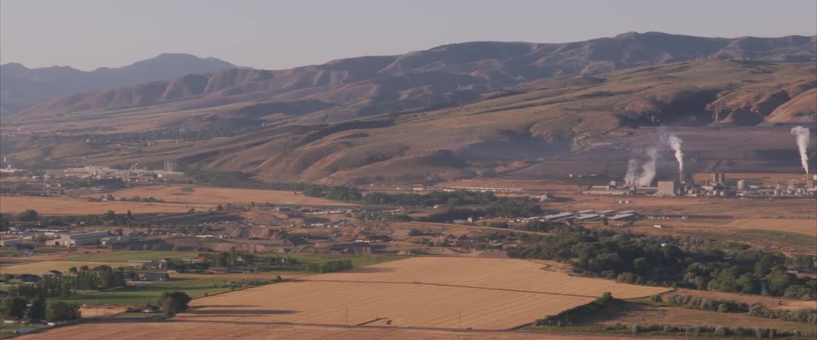 Homes and industrial factories sit below a mountain range