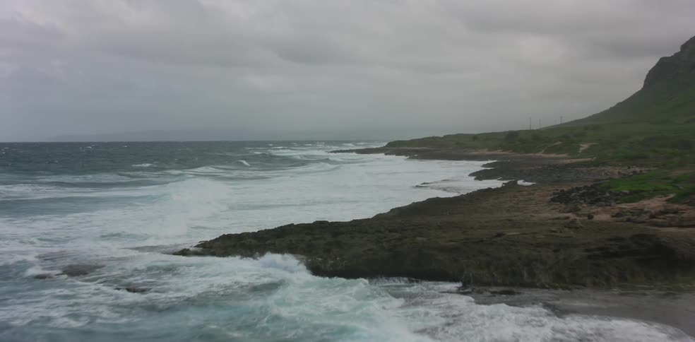 An aerial view of ocean waves washing ashore a beach
