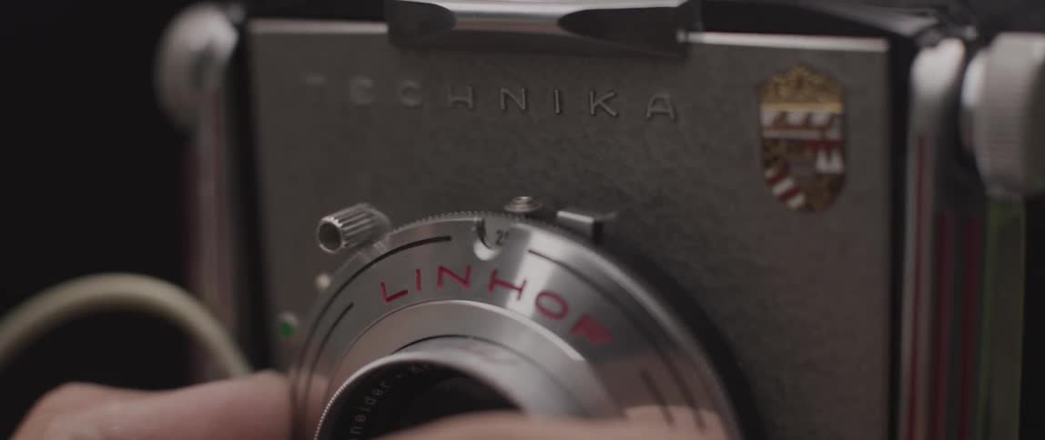 A photographer adjusts the lens of a vintage camera