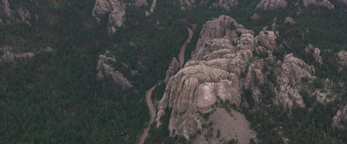 Birds eye view of a canyon a road and a forest
