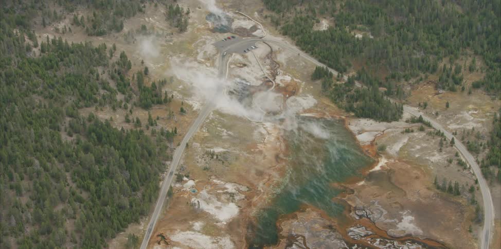 Aerial view of a valley with a small body of water surrounded by roads