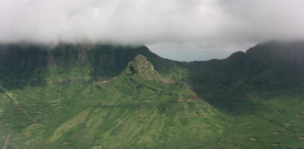 Low clouds over grass covered mountains