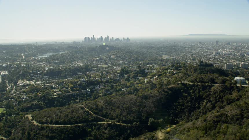 Forested hills rise in front of a large city
