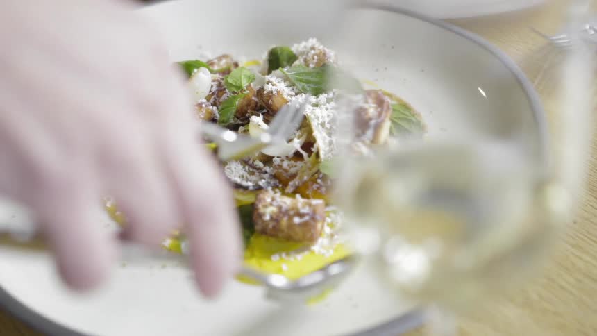 A person eats from an ornately plated plate of food