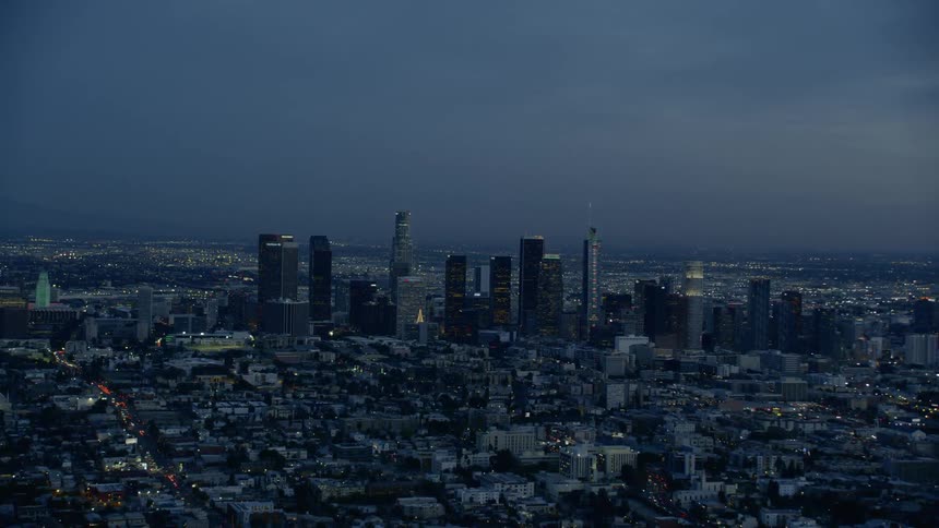 An aerial view of a downtown city at night is displayed