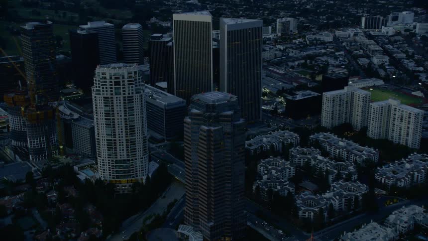 Skyline of the city with tall buildings and houses at dusk