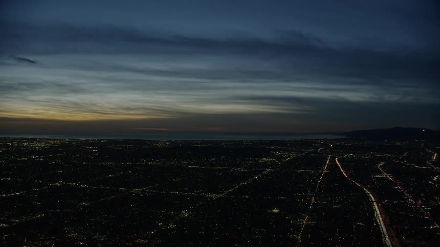Aerial view of a city grid near the ocean at sunset
