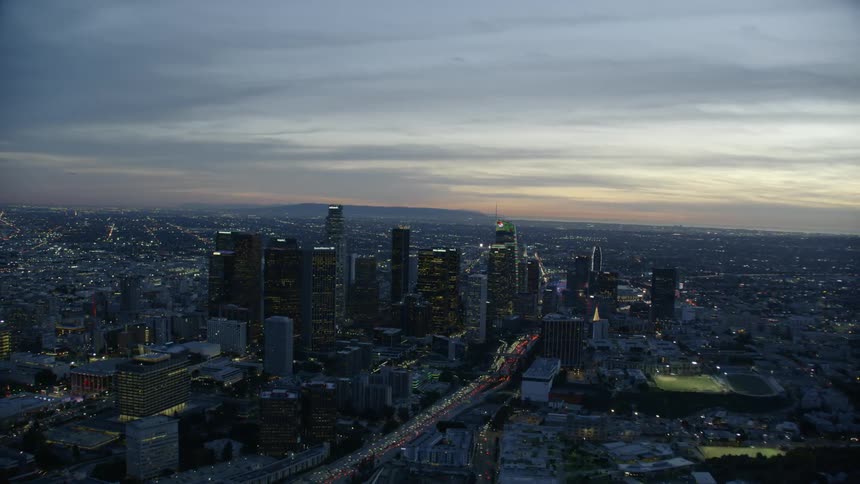 Sweeping aerial view of downtown urban city skyline during evening rush hour