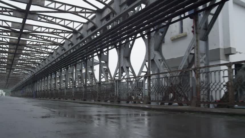 Water puddles sit on a long bridge