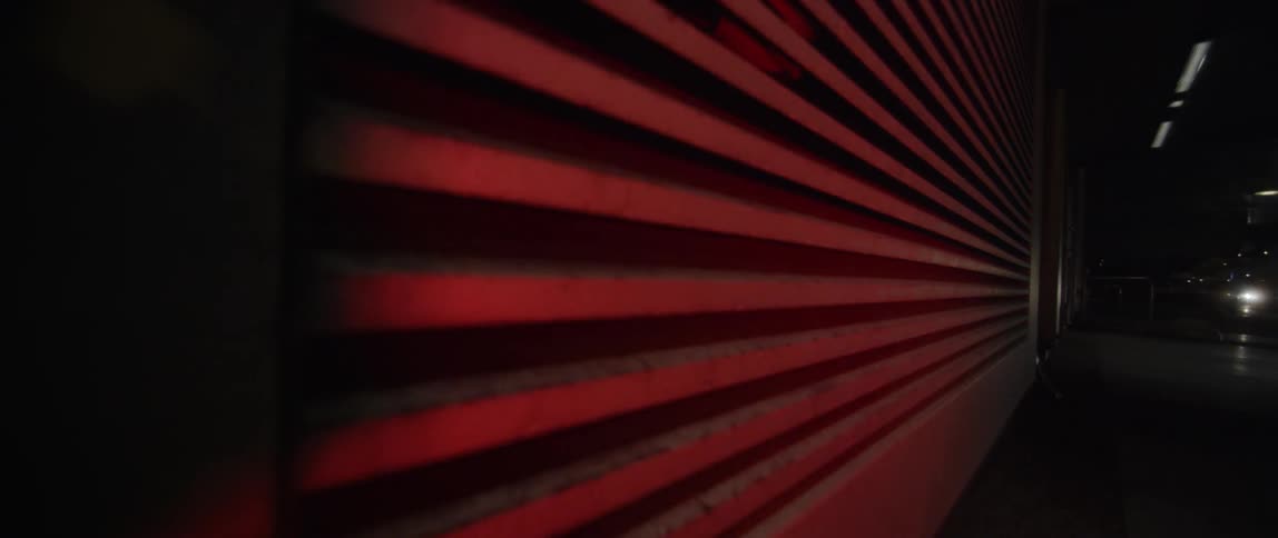 Red flashing light reflects off a garage door