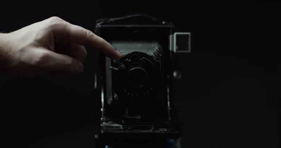 A person activates the shutter on an antique camera