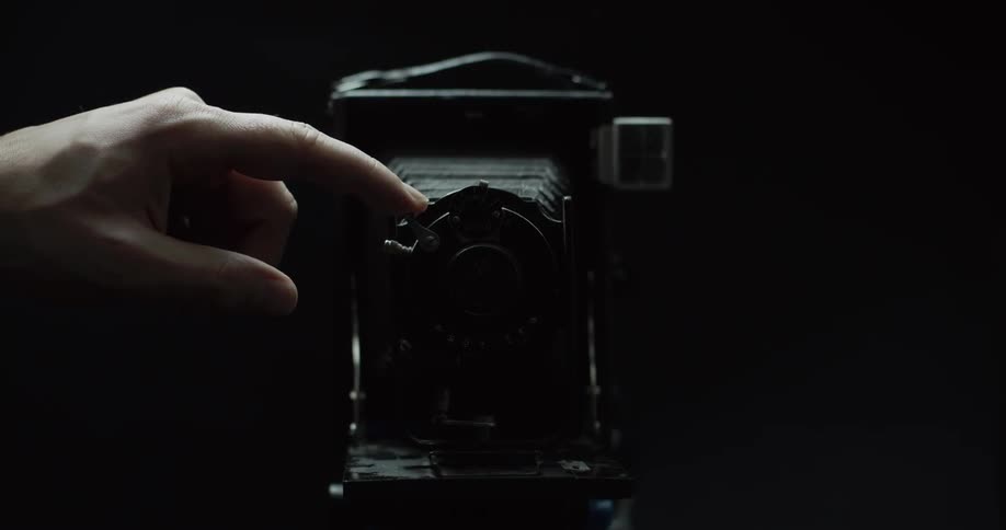 A person hits the shutter on an antique camera