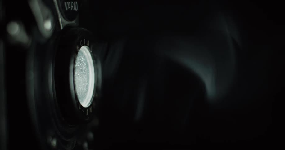 Light reflects off the lens of a vintage camera