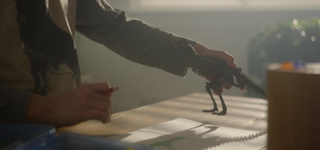 A young boy plays with his toy dinosaur
