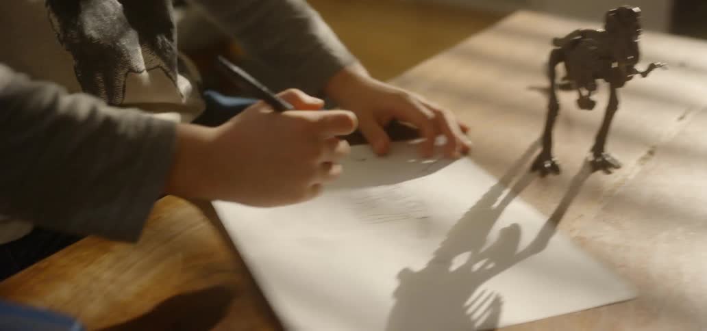 Child draws on paper at table