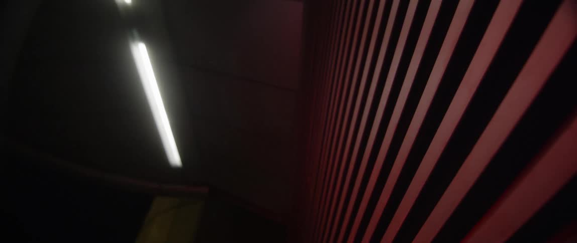 Red painted slats on wall under fluorescent bulbs
