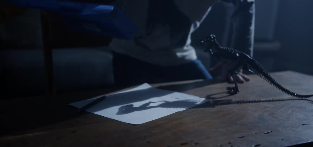 A child walks over and puts pencils on the table