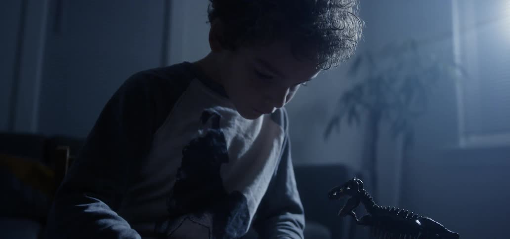 A young boy draws on a piece of a paper