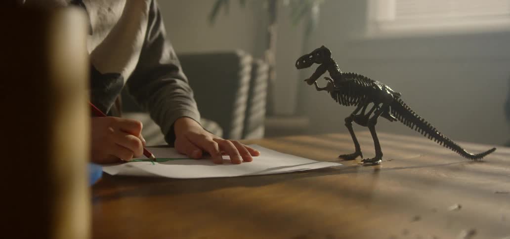 A child draws his toy on the table