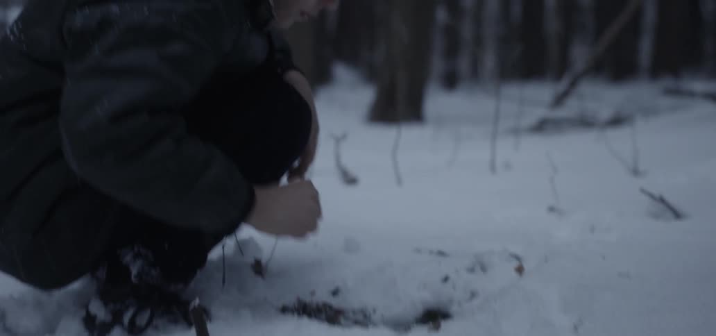 Child reaches into hole in snowy ground jerking back