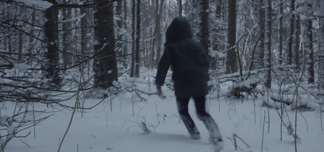 A young boy runs in the snow