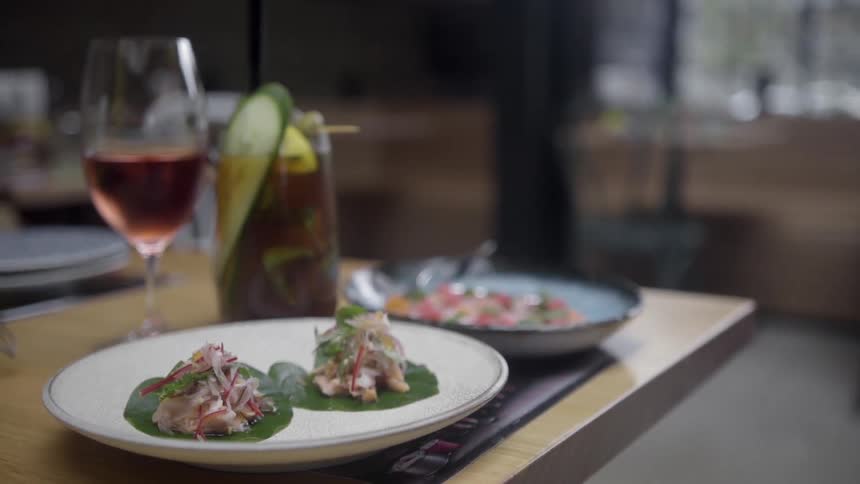 Prepared food and drinks sit on the corner of a dining table ready to be eaten