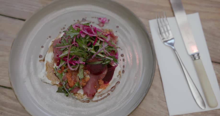 An overhead view of a filled dinner plate placed on a wooden tabletop