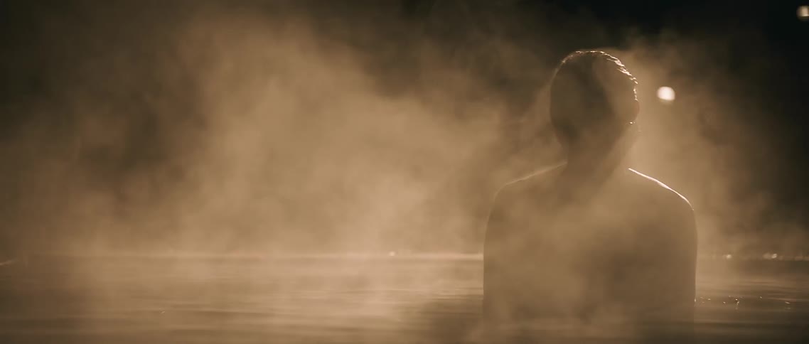 Woman coming up out of the water in the dark