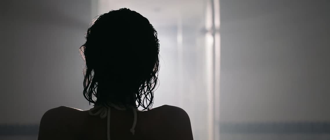 A woman with wet hair sitting in a dim room