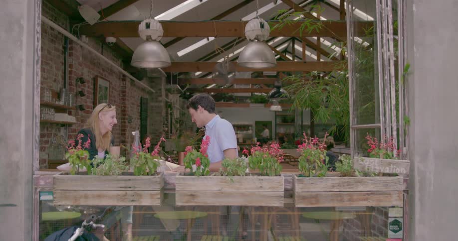 A man and woman sit and chat in a restaurant