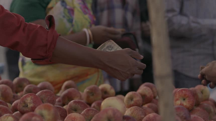 A man buys fruit in a market