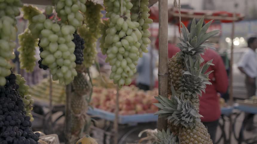Grapes and pineapples handing at a stand