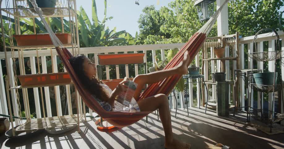 A girl gets into a hammock to read