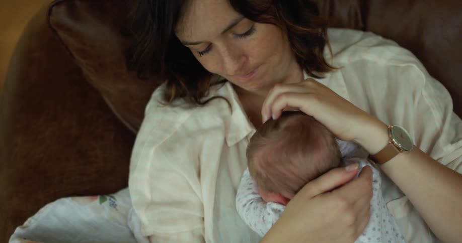 Mother holds and kisses baby