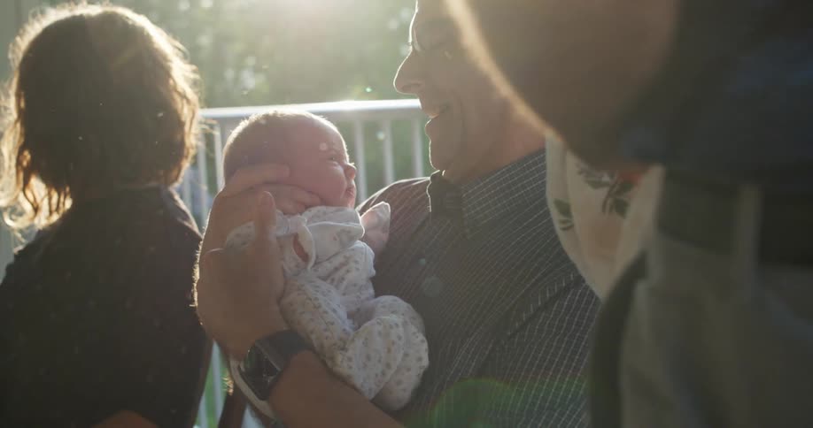 A man holding and smiling at a baby