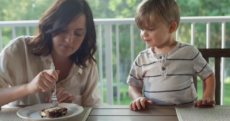 Mother and son are sitting at the table together