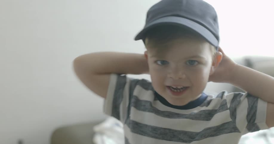 A young boy smiles and waves