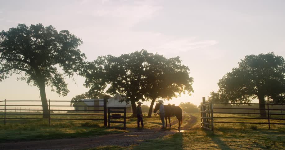 Two men standing next to a horse with trees and a house in the background
