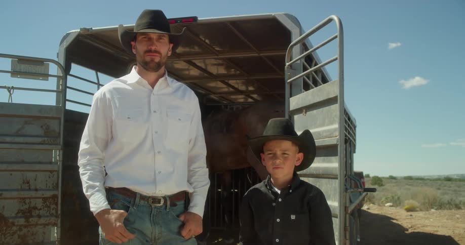 A man and child stand new the trailer