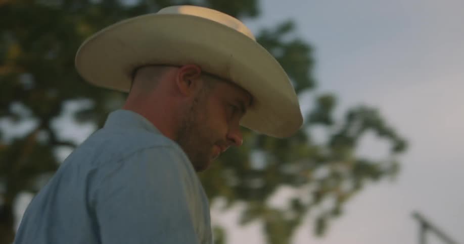 A man in a cowboy had walking through the yard of a house