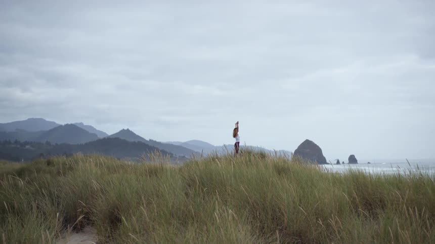 A woman doing yoga on the coast