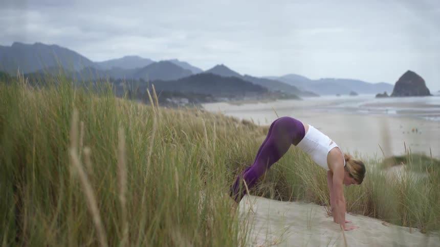 A woman doing yoga on the beach