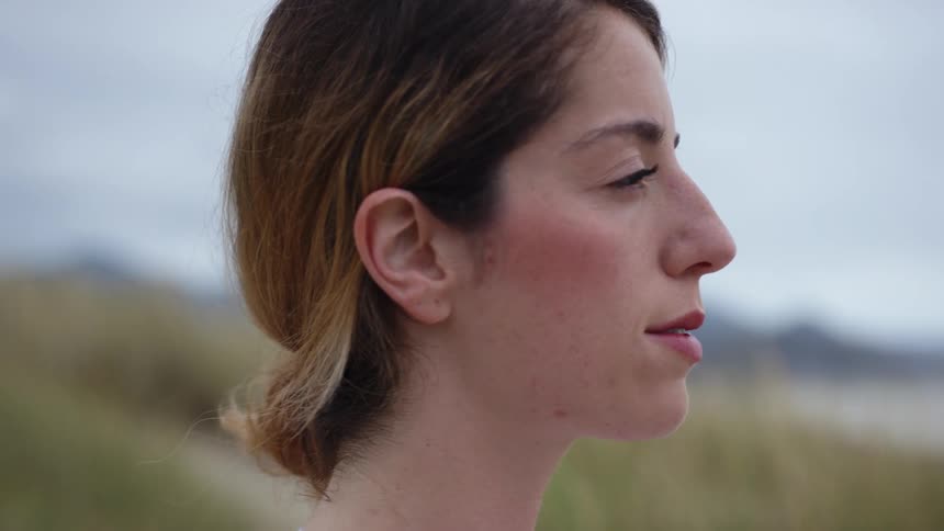 A woman breathing deeply on the beach