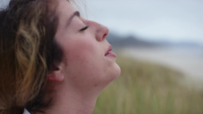 A young woman does yoga on the beach