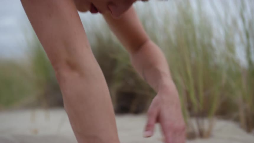 A woman performing stretches on the beach