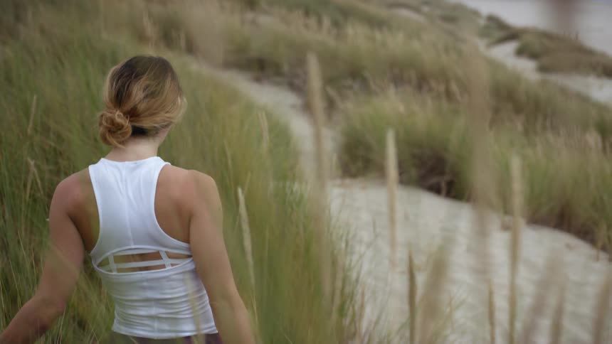 A young woman walks towards the beach