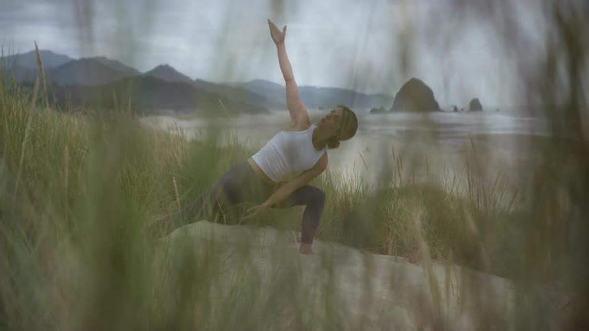 A woman doing yoga on the beach
